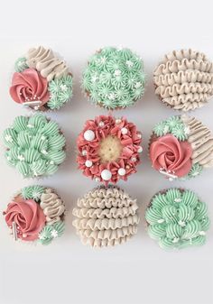 twelve cupcakes decorated in different colors and designs