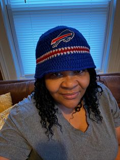 a woman sitting on a couch wearing a knitted beanie hat with the buffalo logo