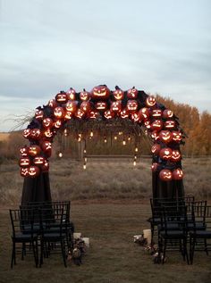 an archway decorated with pumpkins and jack - o'- lanterns for the ceremony