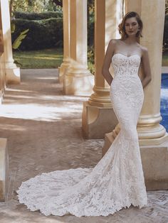 a woman in a white wedding dress standing next to an outdoor gazebo with columns