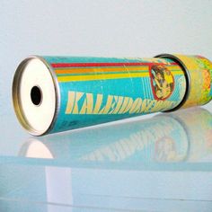 an old tin can sitting on top of a glass table next to a white wall