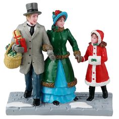 Resin figurine for a Lemax Village display. Designed to look like a mom, a dad and a young girl dressed in winter clothes. The dad is carrying a basket of presents. The ground looks like stone and features two piles of snow. Village Miniature, Lemax Village, Lemax Christmas Village, Christmas Village Accessories, Lemax Christmas, Village Display, Winter Attire, Winter Walk, Christmas Villages