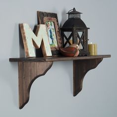 a shelf with some pictures and other items on it, along with a candle holder