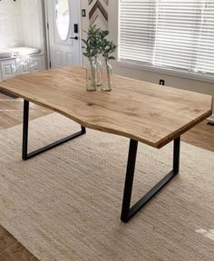 a wooden table sitting on top of a rug in a living room next to a window