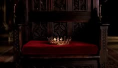 a glass bowl sitting on top of a green cushion in a room with wood paneling