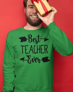 a man holding a present box over his face with the words best teacher ever written on it