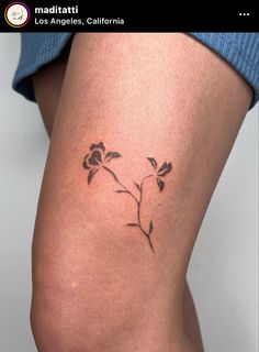 a woman's thigh with a small rose tattoo on the lower half of her leg