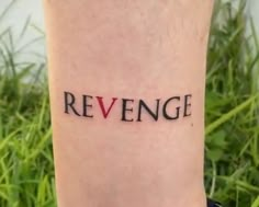 a person with a small tattoo on their leg that says, revenge in black ink