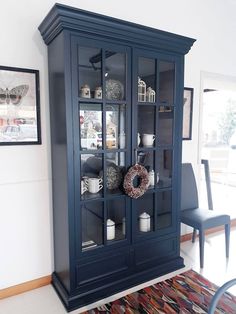 a blue china cabinet with glass doors in a living room