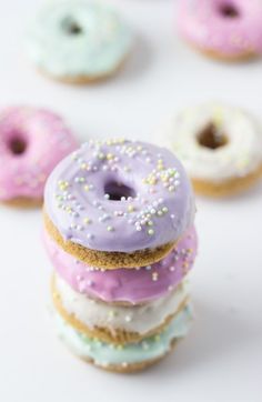 several donuts with frosting and sprinkles are arranged on a white surface