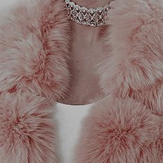 a woman wearing a pink fur coat and diamond necklace