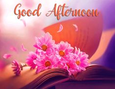 an open book with pink daisies on it and the words good afternoon written in orange