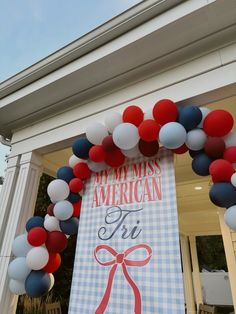 an american triathlon sign is decorated with red, white and blue balloons