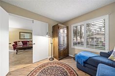 a living room with blue couches and a rug on the floor in front of windows