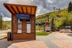 the park city ticket booth is located on the side of the road with mountains in the background