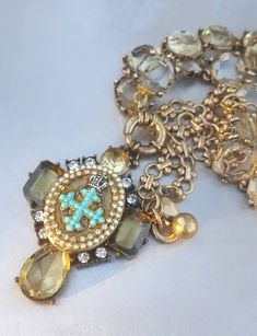 "Original design of this Limited edition statement assemblage necklace, consist of several repurposed parts. Chain: vintage style crystal alike bracelets pieces, attached to cross alike resin pendant base with a central part of pendant:  unique design antique brass locket featuring small  turquoise and antique silver tiny crown, coated with glass like resin and bordered with crystal rhinestones and faux pearls on metal bronze ring base with opal rhinestones. Length of this exceptional necklace is adjustable, and there is Shorter and Longer version.  Shorter Length: chain (adjustable) max approx 19.58\"  (50cm).  Longer Length:  chain (adjustable) max approx 29.53\" (75cm), Pendant size: height 3.15\" (8cm), width 1.771\" (4.5cm)    Please note: real colors may slightly differ from their ap Christian Jewellery, Chunky Crystal Necklace, Cross Necklace Vintage, Large Cross Necklace, 2024 Jewelry, Crystal Locket, Unique Statement Necklace, Vintage Pendant Necklace, Assemblage Necklace