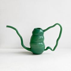 a green watering can sitting on top of a white table