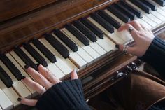 two hands are playing the piano with black and white keys