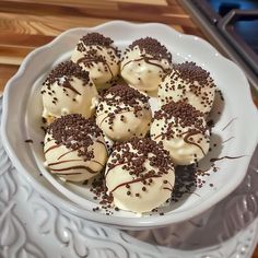 a white bowl filled with chocolate covered desserts