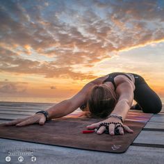 a woman is doing yoga on the beach