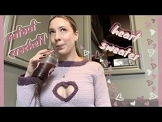 a woman is drinking from a cup in front of a pink and white frame with hearts on it