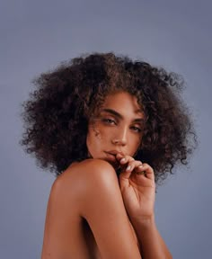 an image of a naked woman with curly hair on her head looking at the camera