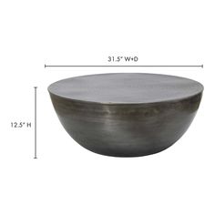 a large metal bowl sitting on top of a white table next to a measuring ruler