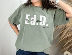 a woman wearing a green t - shirt with the word edd printed on it