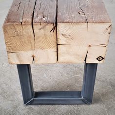 two pieces of wood sitting on top of a metal stand in the middle of a cement floor