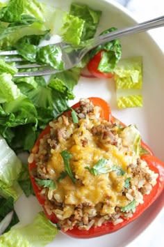 a white plate topped with lettuce and tomatoes