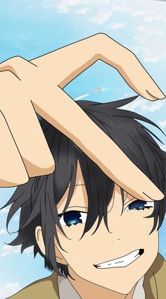 an anime character with black hair and blue eyes is holding his hand up to his head