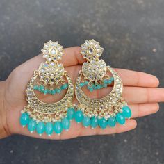 The Teal Sayana Earrings are lightweight chandbalis with Kundan and Gold-Plating on beautiful beaded crystals. Specifications Materials used: Kundan, beaded crystals, Gold Plating Weight: 24 g Height: 3 inches At Romikas, we pride ourselves on the craftsmanship and high quality of our jewelry, designed to enhance your natural beauty. Please contact us with any questions. Beaded Chandelier Earrings For Weddings And Festivals, Wedding Chandelier Earrings With Beads, Chandbali Jewelry With Dangling Beads For Diwali, Bollywood Chandbali Jewelry With Dangling Beads, Bollywood Style Chandbali Jewelry With Dangling Beads, Kundan Chandbalis With Dangling Beads, Jeweled Chandbalis For Festivals, Festival Chandbali Bridal Earrings With Beads, Beaded Chandbali Earrings For Celebration