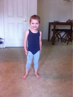 a little boy that is standing in the middle of a room with no shoes on