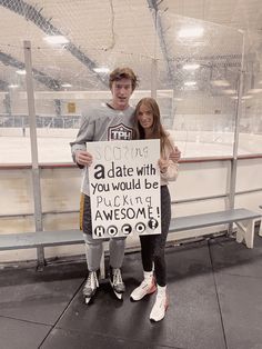 two people standing next to each other holding signs