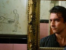 a man looking at himself in the mirror