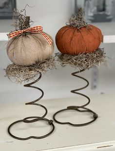 two pumpkins sitting on top of metal wire