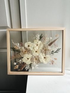 a wooden frame with white flowers in it