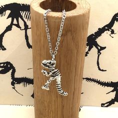 "Dinosaur Necklace, Science Necklace, T-Rex Necklace, Science Jewelry, Silver Dinosaur Necklace, Dinosaur Jewelry, T-Rex Skeleton Necklace  🦖 Jurassic Neck! Be sure you know what you're getting into before you wear this! - pendant is comprised of skin safe zinc alloy - come gift ready on a hand stamped card in a cute organza bag  - chain is skin safe stainless steel in a silver finish - available on a silver chain or a black waxed cotton cord - black cord is adjustable from 18\" to 28\"  We are Skeleton Necklace, Dinosaur Jewelry, Dinosaur Necklace, Science Jewelry, Gifts For My Sister, Silver Chain Necklace, Organza Bags, T Rex, Antique Bronze