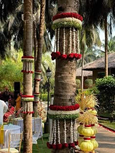 an outdoor area with palm trees, flowers and decorations on the tables at a wedding