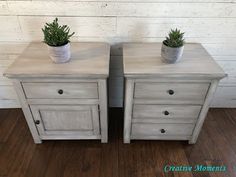 two white wooden nightstands with plants on top