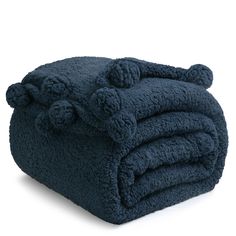 a blue blanket with pom - poms on the top and bottom is folded up