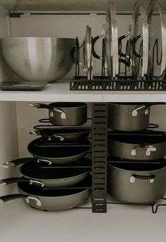 pots and pans are stacked on the shelf