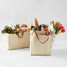 two canvas bags filled with groceries and flowers