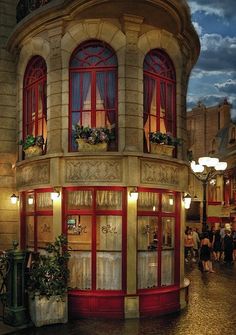 an old fashioned building with red trim and windows