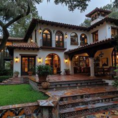 a large white house with lots of windows and steps leading up to the front door