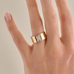 a woman's hand with a gold ring on it and a diamond in the middle