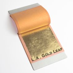 a roll of gold leaf on top of a piece of paper that says la gold leaf