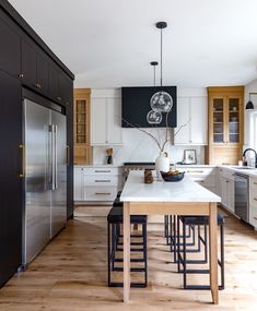 a kitchen with an island, refrigerator and sink in it's centerpieces