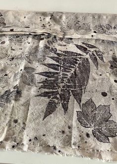 a piece of cloth with black and white flowers on it, sitting on top of a table