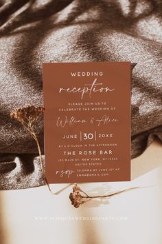 a wedding reception card on top of a bed